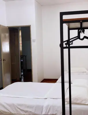 a bedroom with a bed with white sheets and a black frame at Cameron Magpie House in Ringlet