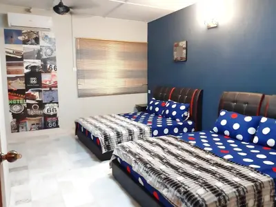 a bedroom with two beds and a couch at G East Ipoh Garden Guesthouse in Ipoh