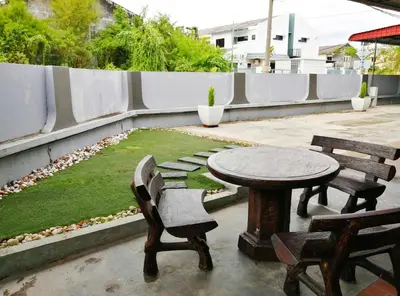 a patio with a table and two chairs and a table and benches at G East Ipoh Garden Guesthouse in Ipoh