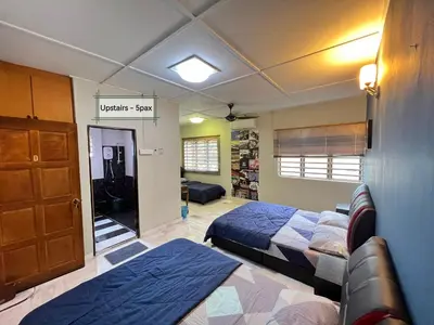 a bedroom with two beds and a couch in it at G East Ipoh Garden Guesthouse in Ipoh