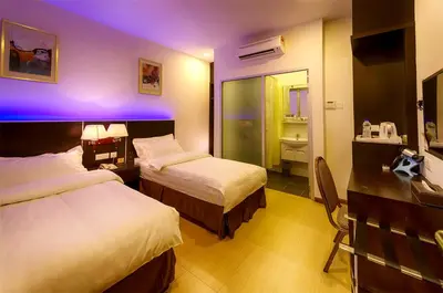 a hotel room with two beds and a purple light at ERNES Hotel Alma Bukit Mertajam in Bukit Mertajam
