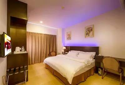 a bedroom with a large bed with purple lighting at ERNES Hotel Alma Bukit Mertajam in Bukit Mertajam
