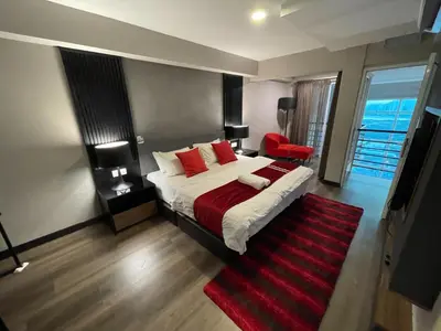 a bedroom with a bed with red pillows and a red rug at Maritime Seaview Hotel by SS Setia Resort in George Town