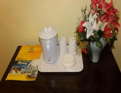 a tray with a candle and a vase with flowers on a table at Sun Inns Tambun in Kampong Batu Lapan