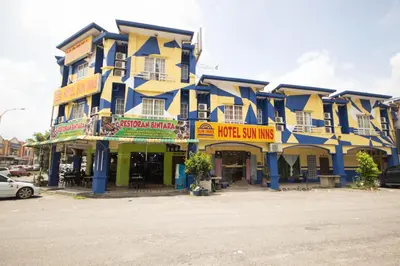 a yellow and blue building with signs on it at Sun Inns Tambun in Kampong Batu Lapan
