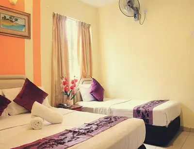 a hotel room with two beds and a window at Sun Inns Tambun in Kampong Batu Lapan