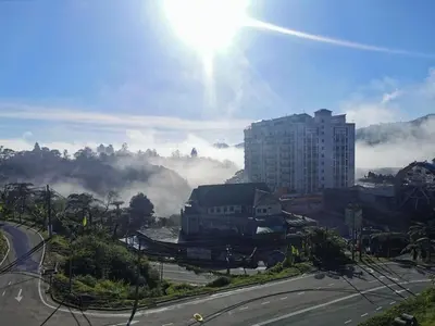 a view of a city with the sun in the sky at The Cocoon Capsule Hotel in Cameron Highlands