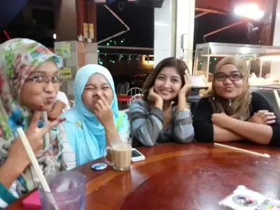 a group of three women sitting at a table at Airbnb at Sri Sayang Batu Ferringhi Beach in Batu Ferringhi