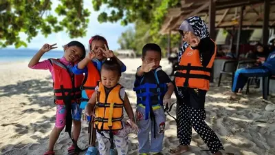 a group of children wearing life jackets on the beach at Airbnb at Sri Sayang Batu Ferringhi Beach in Batu Ferringhi