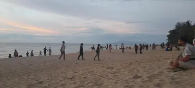 a group of people walking on the beach at Airbnb at Sri Sayang Batu Ferringhi Beach in Batu Ferringhi