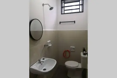 a bathroom with a sink and a toilet and a mirror at Homestay Tok Ayah, Behrang Jati in Kampung Behrang