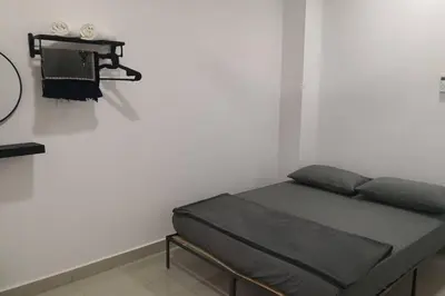 a bed sitting in a room next to a wall at Homestay Tok Ayah, Behrang Jati in Kampung Behrang