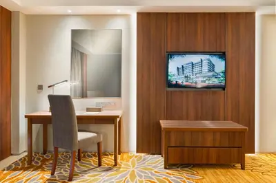 a hotel room with a desk and a television on a wall at Zenith Hotel Cameron in Tanah Rata