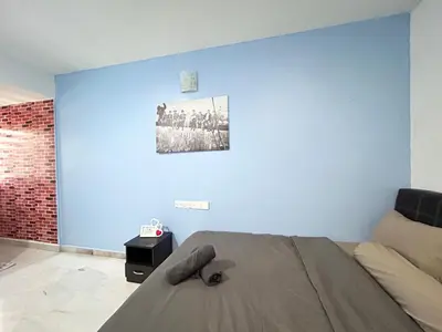 a bedroom with a bed and a blue wall at Ipoh Comfortable Rooms Only-Private Bathrooms Indoor Car Parking SY30 in Ipoh