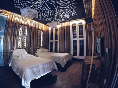 a bedroom with two beds and a wall with zebra wallpaper at The Happy 8 Retreat @ Old Town Ipoh in Ipoh