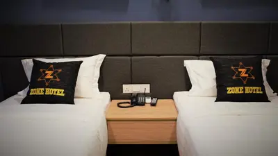 a room with two beds and a table with a phone at Zone Hotel Ipoh in Ipoh