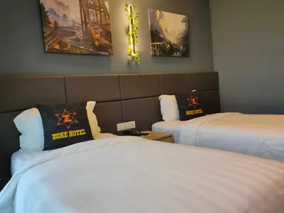 a hotel room with two beds and pictures on the wall at Zone Hotel Ipoh in Ipoh