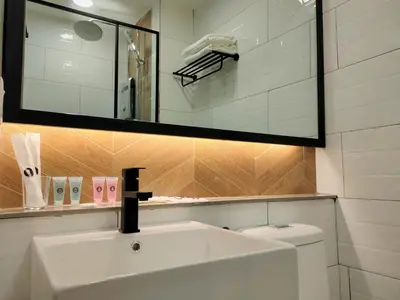 a bathroom with a sink and a mirror and a toilet at Zone Hotel Ipoh in Ipoh