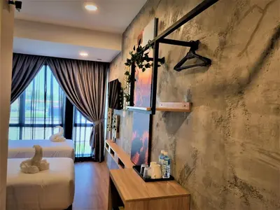 a bedroom with two beds and a large window at Zone Hotel Ipoh in Ipoh