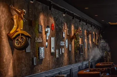 a wall with a mural of buildings and a scooter at Zone Hotel Ipoh in Ipoh