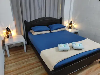 a bedroom with a bed with blue sheets and blue pillows at RAHIM HOMESTAY KUALA KANGSAR in Kuala Kangsar