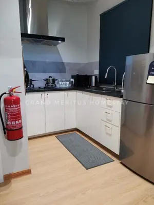 a kitchen with a stainless steel refrigerator and a wooden floor at Grand Meritus Homestay @Penang in Perai