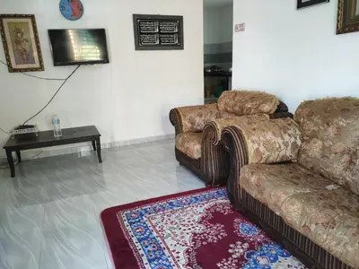 a living room with a couch and a table at Nurul Saadah Lunas in Lunas