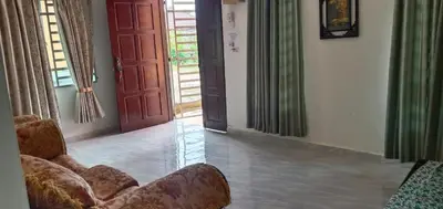 a living room with two chairs and an open door at Nurul Saadah Lunas in Lunas