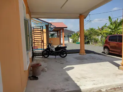 a motorcycle parked on a porch of a house at Nurul Saadah Lunas in Lunas