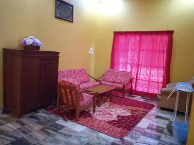 a room with two chairs and a table and pink curtains at Enalys Homestay untuk orang islam sahaja in Kampung Bota Kiri