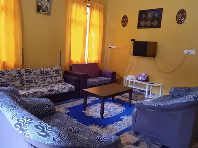 a living room with couches and a table and a tv at Enalys Homestay untuk orang islam sahaja in Kampung Bota Kiri