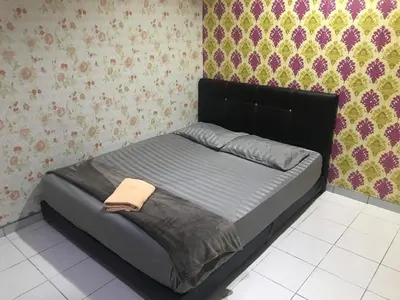 a bed with a black headboard in a bedroom at No 96 Nazirin Homestay Lumut in Lumut