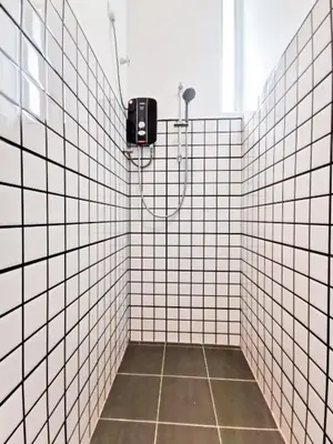 a bathroom with a shower with white tiled walls at Garden Home Ipoh in Ipoh