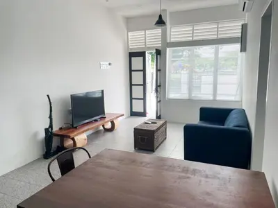 a living room with a table and a couch and a tv at Garden Home Ipoh in Ipoh