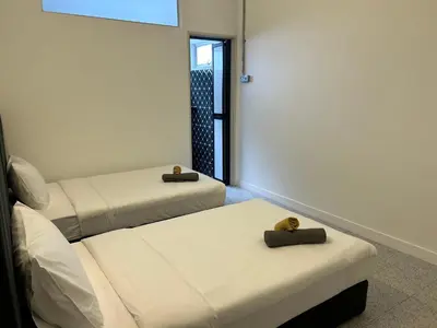 a room with two beds and a window at Garden Home Ipoh in Ipoh