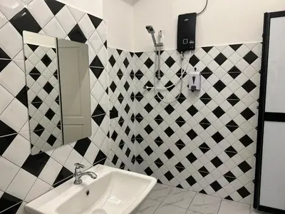 a bathroom with a sink and black and white tiles at Garden Home Ipoh in Ipoh