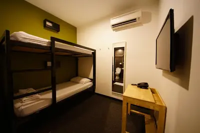 a small room with a bunk bed and a table at Tulip Hotel in Ipoh