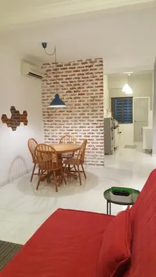 a living room with a table and chairs and a brick wall at Tulip Hotel in Ipoh