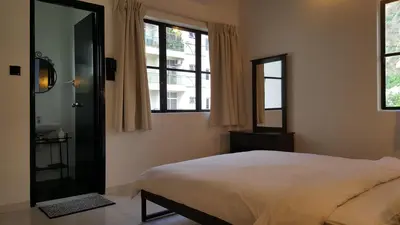 a bedroom with a bed and a mirror and windows at Tulip Hotel in Ipoh