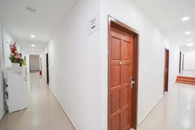 a hallway with a wooden door in a building at JMA FERRINGHI BEACH HOTEL in Batu Ferringhi