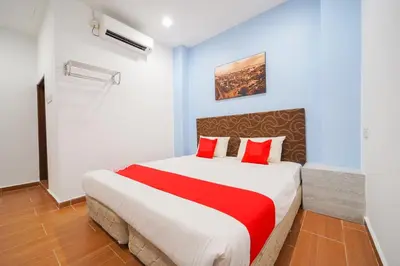 a bedroom with a large bed with red pillows at JMA FERRINGHI BEACH HOTEL in Batu Ferringhi