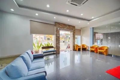 a living room with a blue couch and chairs at JMA FERRINGHI BEACH HOTEL in Batu Ferringhi