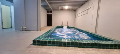 a swimming pool with a tile floor in a building at JMA FERRINGHI BEACH HOTEL in Batu Ferringhi