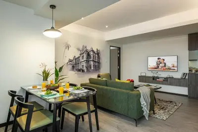 a living room with a green couch and a table at Citadines Prai Penang in Bukit Mertajam
