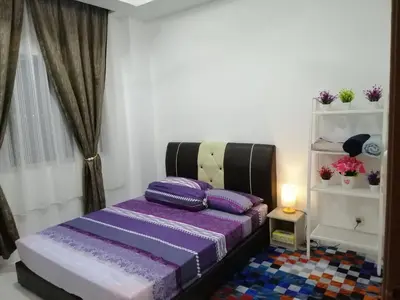 a bedroom with a purple bed with pillows on it at Onies Homestay Lumut Manjung in Lumut