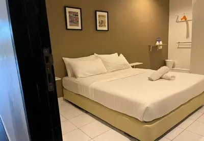 a bedroom with a large bed with white sheets at 1108 Hotel Sungkai in Sungkai