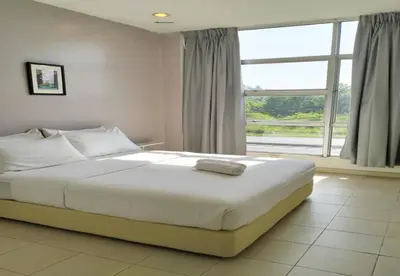 a bedroom with a large bed and a large window at 1108 Hotel Sungkai in Sungkai