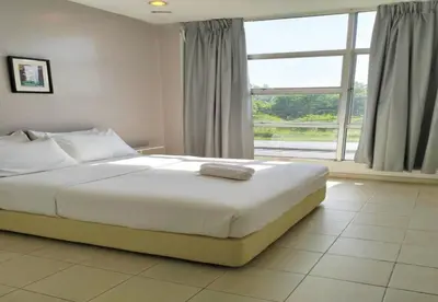 a bedroom with a large bed with a large window at 1108 Hotel Sungkai in Sungkai