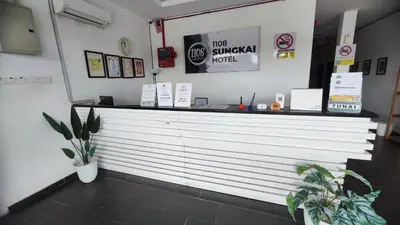 a white counter in a restaurant with potted plants at 1108 Hotel Sungkai in Sungkai