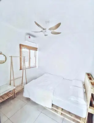a white bedroom with a bed and a ceiling fan at One Life Four Season Waterpark Guest House Manhattan Condominium in Ipoh
